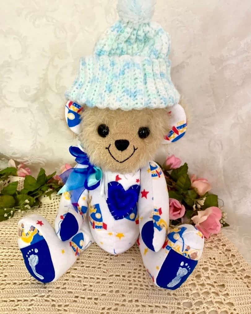 Keepsake bear made from baby clothing with knitted cap.
