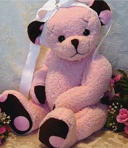 Pink baby bear with brown ears and paws.