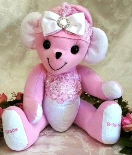 Teddy bear made from pink and white with big bow.
