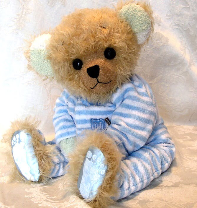 Plush teddy ber made with blue striped sleeper.